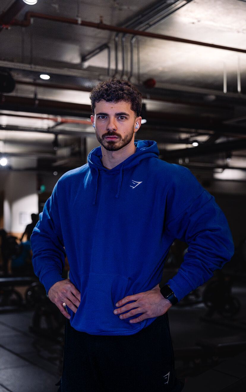Bogdan Calinescu in a blue hoodie, direct gaze, hands on hips